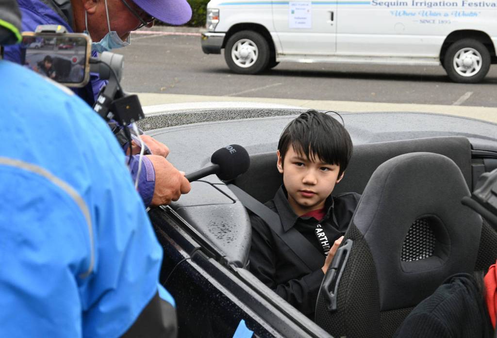 Mason Blake, winner of the 2021 Irrigation Festival Button Design contest, talks with festival emcee Stephen Rosales before the Grand Parade on May 8. Like his grandfather before him, Blake is a two-time button design contest winner. Sequim Gazette photo by Michael Dashiell