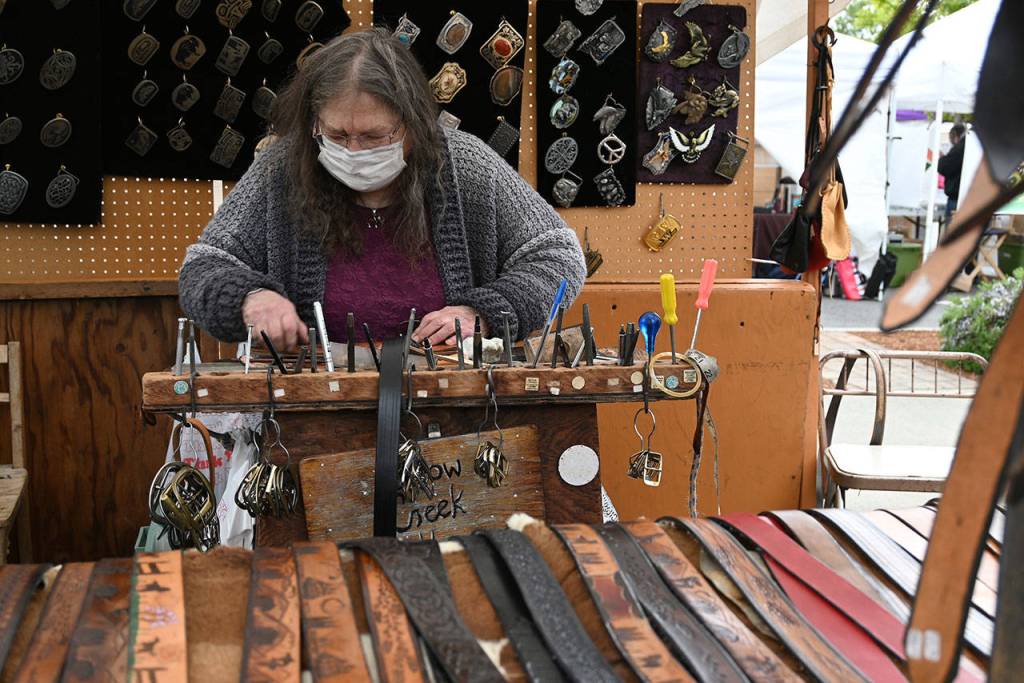 Jenny Preston of Chimacums Snow Creek Leather works on a belt at the Sequim Irrigation Festivals Innovative Arts and Crafts Fair in downtown Sequim Saturday, May 8. Ive been coming to this festival since as long as I can remember, possibly the 1970s, Preston said. With health restrictions in place the festival moved all but two events  the fair and the Grand Parade-turned-procession  to virtual presentations. See irrigationfestival.com. Sequim Gazette photo by Michael Dashiell