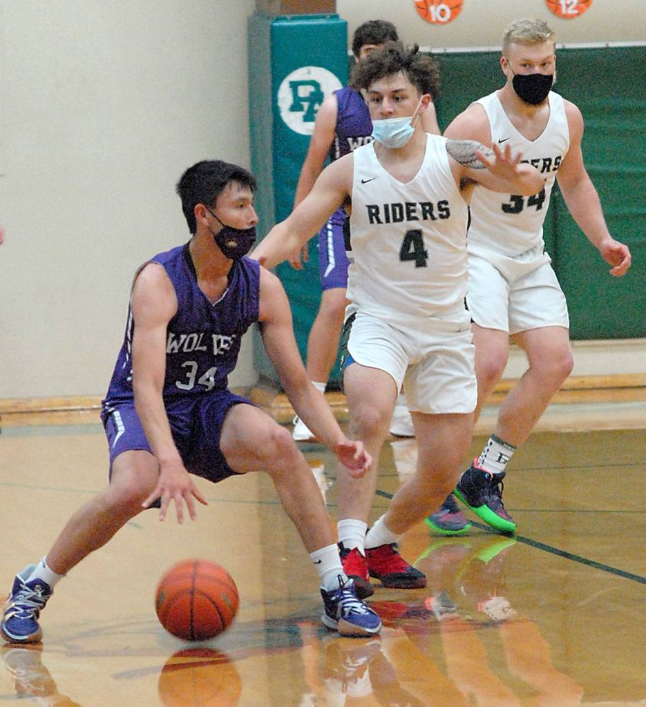 Sequims Isaiah Moore, left, is defended by Port Angeles Jeremiah Hall, center, and Adam Watkins in the first quarter of play at Port Angeles High School on May 12. Photo by Keith Thorpe/Olympic Peninsula News Group