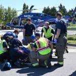 Personnel with Life Flight Network, Olympic Ambulance and Clallam County Fire District 3 secure a patient for transport Friday morning from a helipad in Sequim. The 69-year-old Port Angeles man was injured in a single car roll-over on U.S. Highway 101. Sequim Gazette photo by Michael Dashiell
