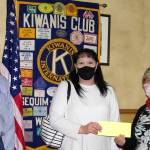 President Ted Lund, on left, and treasurer Philomena Lund of the Kiwanis of Sequim-Dungeness, on right, present Nicole Goettling, owner-director of Bibity Bobity, a check for $275 to help install a shaded area outside for learning and play as part of a Kiwanis mini-grant program. Submitted photo