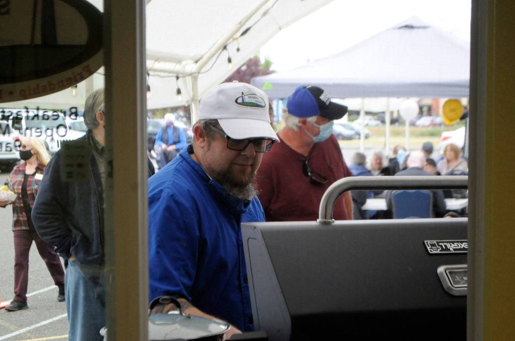 Kurt Engel, chef and cafe manager for the recently rebranded Leos Café at Shipley Center, grills hot dogs for participants of the centers 50th anniversary on May 27. Sequim Gazette photo by Matthew Nash