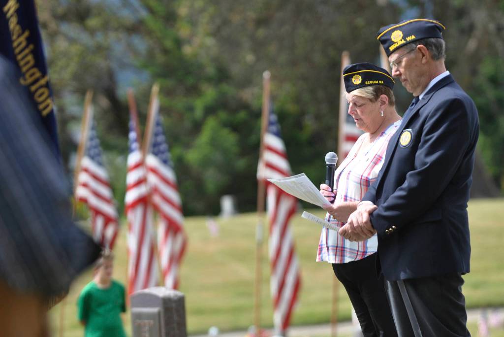 Nancy Zimmermann, chaplain for American Legion Post 62, offers a prayer at the May 31 Memorial Day ceremony at Sequim View Cemetery. At right is Post commander Paul Renick. Sequim Gazette photo by Michael Dashiell