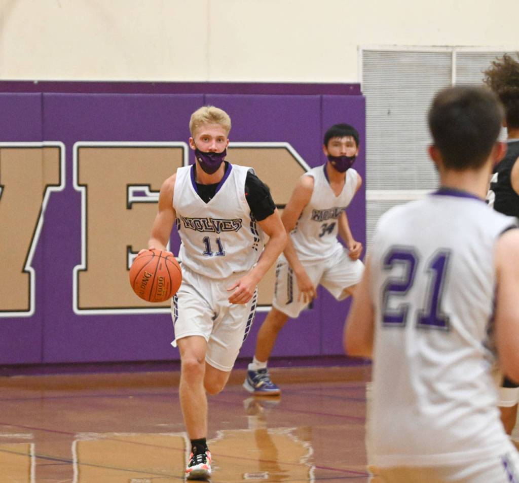 Sequim guard Erik Christiansen looks for a teammate as he brings the ball upcourt in the Wolves loss to class 3A Central Kitsap on June 2. Sequim Gazette photo by Michael Dashiell