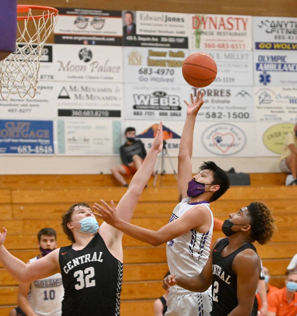 Sequims Isaiah Moore puts up a shot as Central Kitsaps Ian Massey and Maurice Green defend in the Wolves 72-49 loss to Central Kitsap on June 2. Sequim Gazette photo by Michael Dashiell