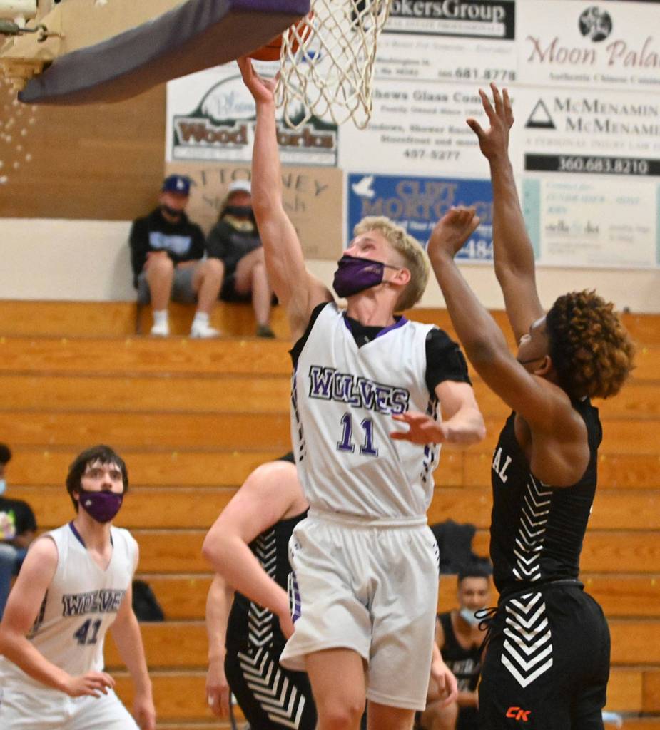 Sequim guard Erik Christiansen drives past Maurice Green to the basket for a score in the Wolves 72-49 loss to Central Kitsap on June 2. Sequim Gazette photo by Michael Dashiell