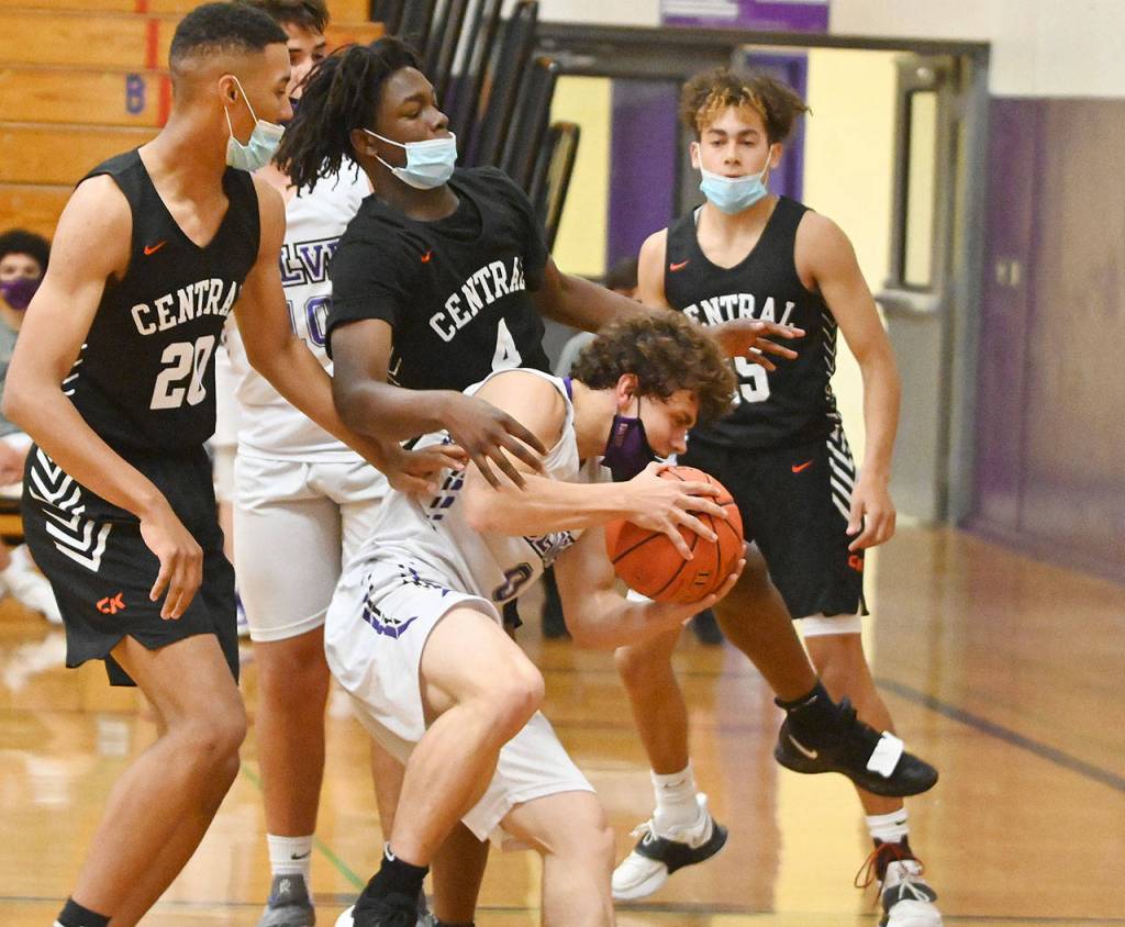 Sequims Tyler Mooney, center, wrestles an offensive rebound away from Central Kitsap Cougars in the Wolves 72-49 loss on June 2. Defending the play are Zavion Stringer, left, and Jo Jo Johnson. Sequim Gazette photo by Michael Dashiell