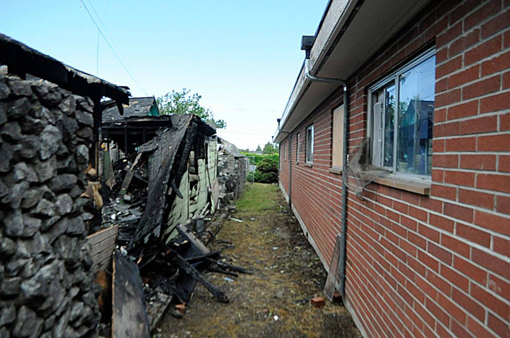 Sequim Police officers evacuated a nearby apartment building by the house fire for safety. The fire burned adjacent windows, but no other damage was reported to the apartments, fire officials report. Sequim Gazette photo by Matthew Nash