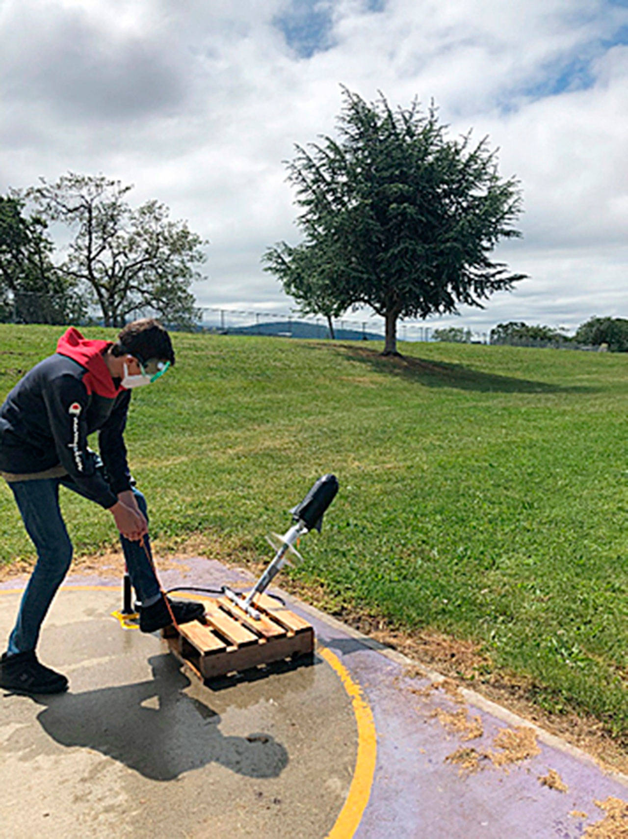 Sequim Middle School student Sam Cobb prepares to launch his pressurized 2-liter bottle rocket. Sams rocket traveled 98 meters. Photo by Joe Landoni