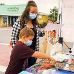 Rebecca and Abel, Sequim Farmers & Artisans Markets SNAP ambassadors, redeem SNAP currency at the market. Photo by Emma Jane EJ Garcia