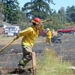 Fire District 3 personnel put out hot spots at a brush fire in Carlsborg in July 2019. Sequim Gazette file photo by Michael Dashiell