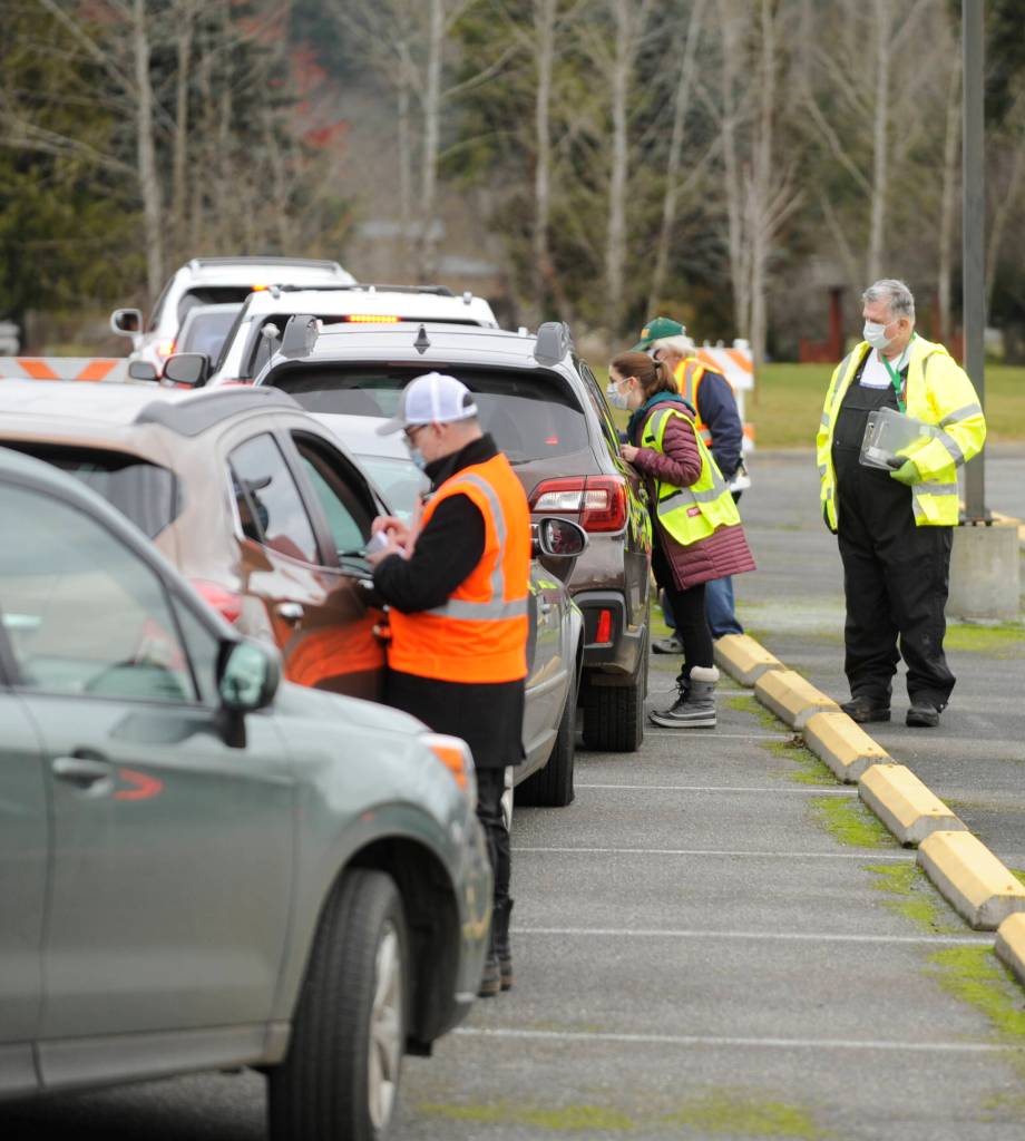 Jamestown Family Health Clinic staff and Community Emergency Response Team (CERT) members help individuals get registered for COVID-19 vaccinations at the tribes clinic in January. Those assisting include (in background) Dr. Molly Martin, deputy medical director at the Jamestown SKlallam Tribe, and CERT member Jim Johnston. Sequim Gazette file photo by Michael Dashiell