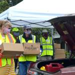 Volunteers Nancy Elwert and Bruce Leigh with Community Emergency Response Teams (CERT) ready to place food boxes in a trunk at Sequim High School in June 2020. Sequim Gazette file photo by Matthew Nash