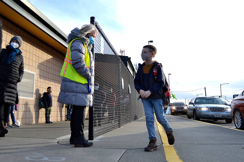 First grade teacher Pattie Hagan greets James Keehn back to school at Helen Haller Elementary in January after COVID-19 precautions led school leaders to move to distance learning. Sequim Gazette file photo by Matthew Nash
