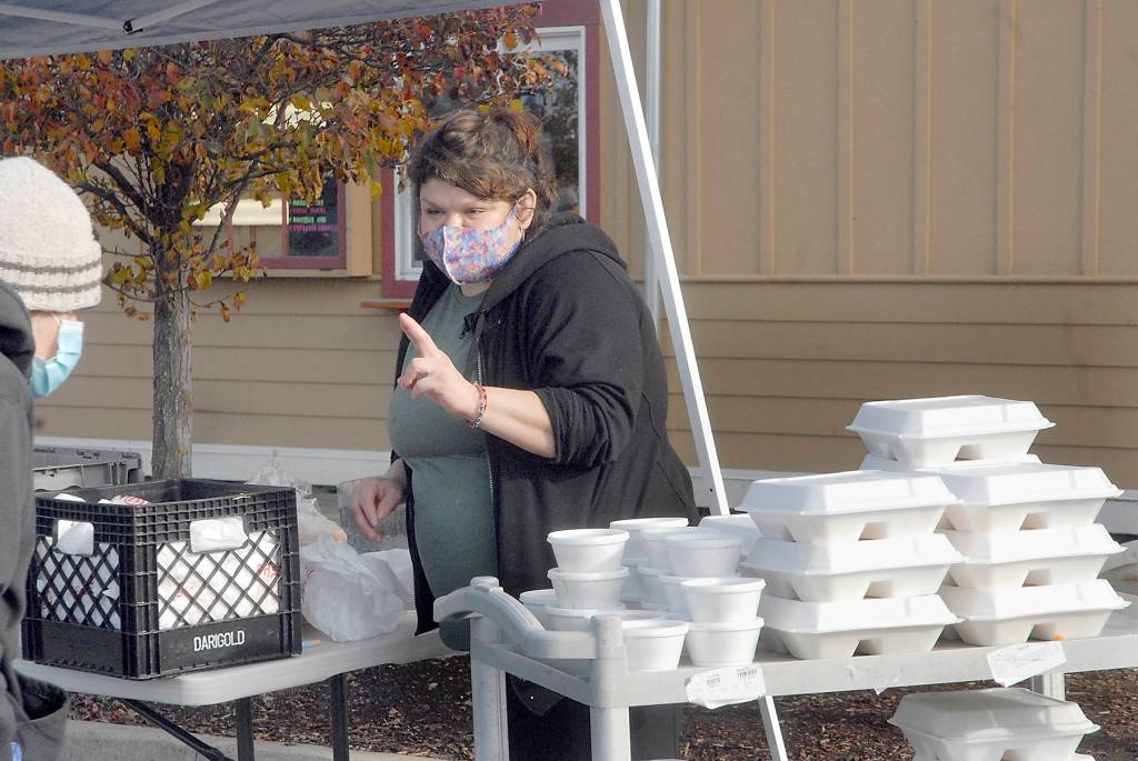 Sendy Alvarez, manager of Hardys Market, takes a dinner order outside the Sequim convenience store and deli on Thanksgiving Day 2020. In an annual tradition, the market gave away traditional turkey dinners to people, foregoing inside service in favor of walk-up delivery to adhere to COVID-19 distancing guidelines. FIle photo by Keith Thorpe/Olympic Peninsula News Group