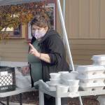 Sendy Alvarez, manager of Hardys Market, takes a dinner order outside the Sequim convenience store and deli on Thanksgiving Day 2020. In an annual tradition, the market gave away traditional turkey dinners to people, foregoing inside service in favor of walk-up delivery to adhere to COVID-19 distancing guidelines. FIle photo by Keith Thorpe/Olympic Peninsula News Group