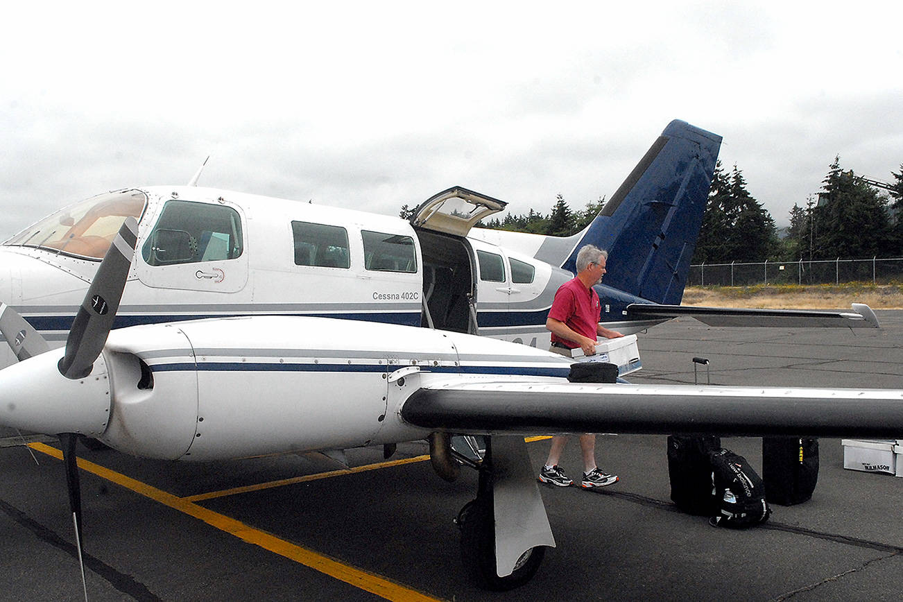 Aspiring Dash pilot Josh Crabtree of Port Angeles unloads boxes of maintenance records from a Dash Air Shuttle Cessna 402C on Wednesday, June 30, at William R. Fairchild International Airport in Port Angeles. Photo by Keith Thorpe/Olympic Peninsula News Group