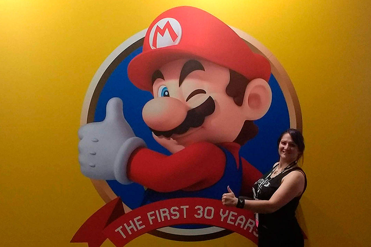 Jenny Blenk, formerly of Sequim, stands by a banner for the Super Mario Bros. Encyclopedia at the 2018 San Diego ComicCon. Blenk said it was one of the most grueling books I ever worked on. Photos courtesy of Jenny Blenk