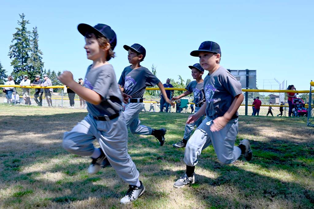 Sequim Little League players race onto Don Knapp Field as part of the season-closing ceremonies.