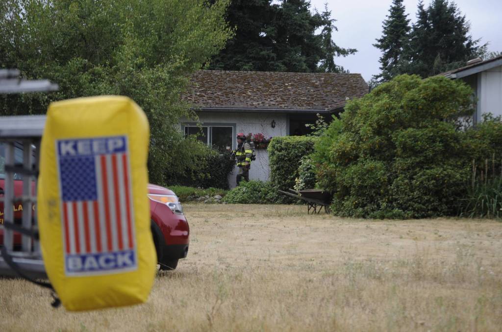 Firefighters on July 14 access a home on the 1000 block of West Palo Verde Loop to make sure a fire is extinguished. Sequim Gazette photo by Matthew Nash