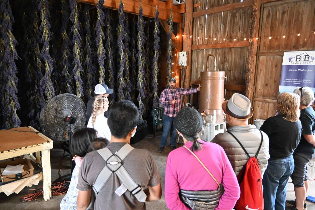 Zion Hilliker, co-owner of B&B Family Farm, talks with a tour crowd inside the farms drying barn Friday afternoon. Sequim Gazette photo by Michael Dashiell