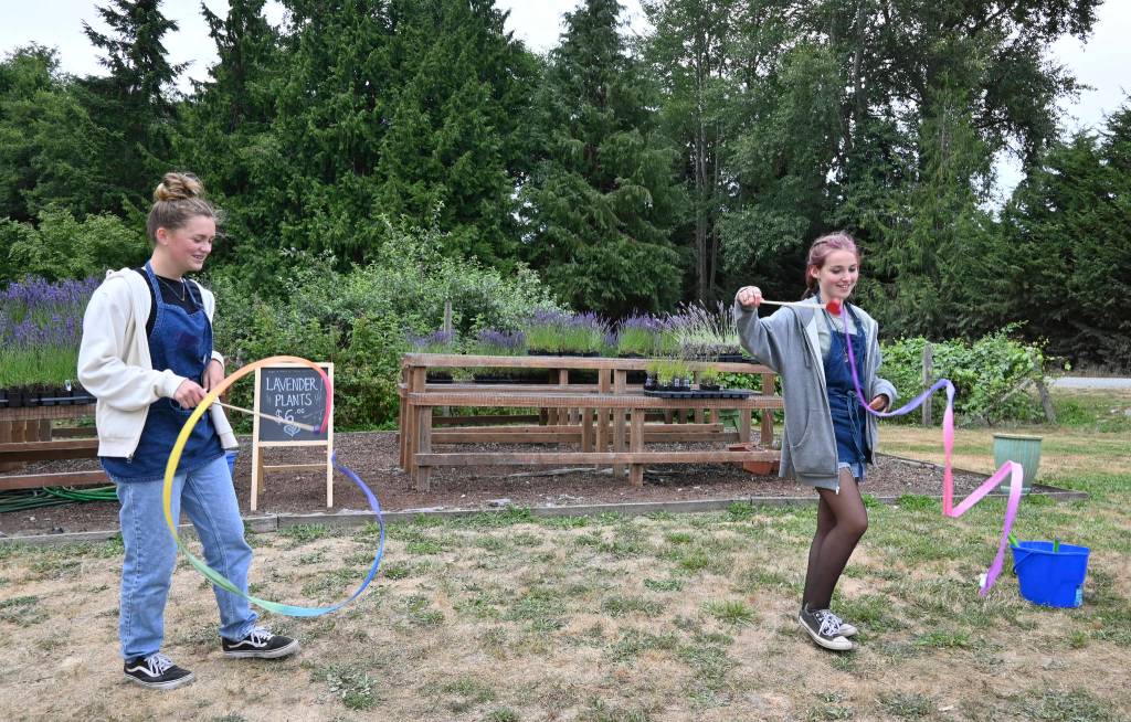 Beige Kenzie Bergelund and grey Sydney Clark break from their farm pass purchase responsibilities to twirl ribbons at Purple Haze Organic Lavender Farm Friday afternoon. Sequim Gazette photo by Michael Dashiell
