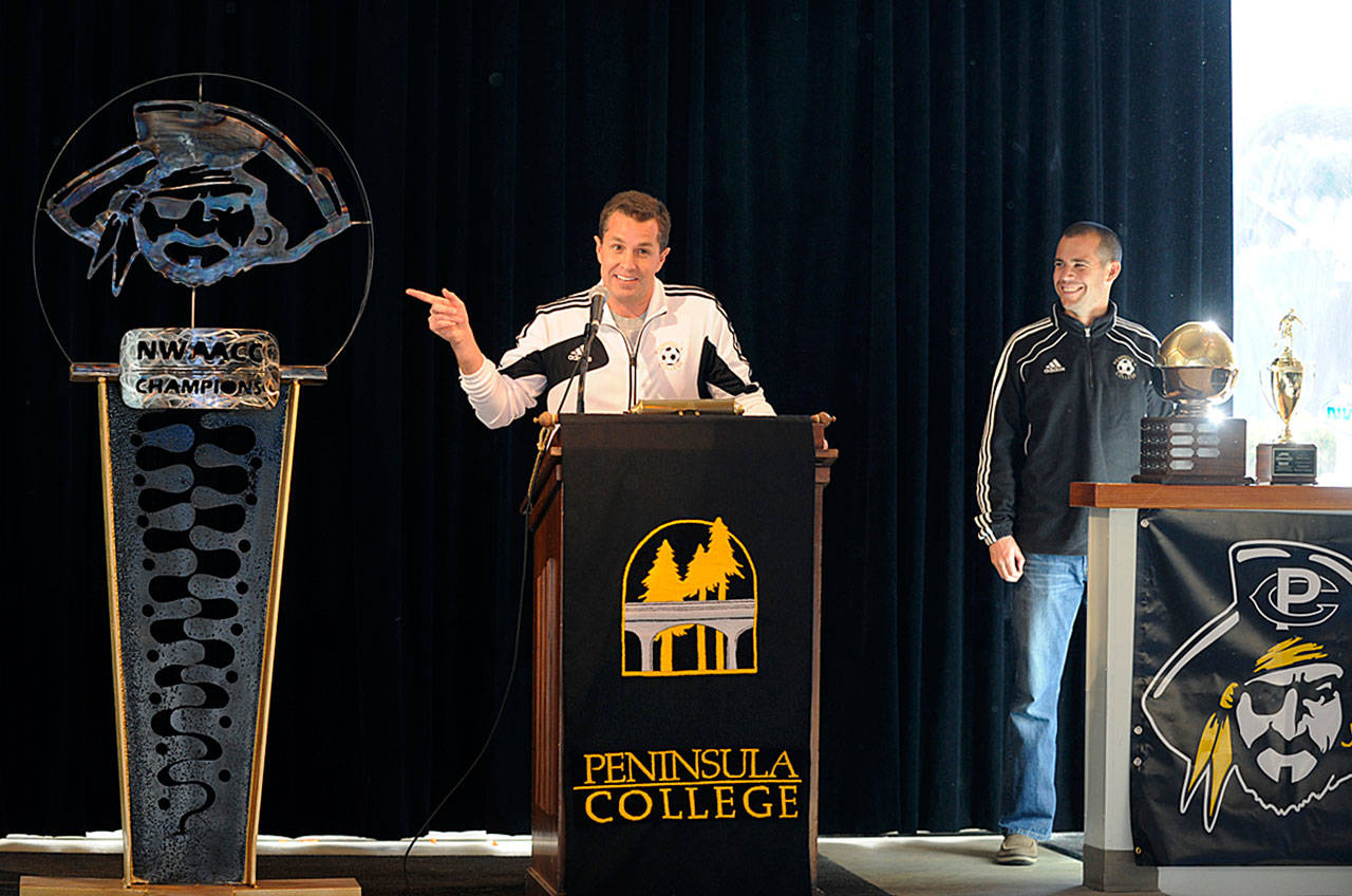 Peninsula College mens soccer coach Andrew Chapman, left, and Peninsula womens coach Kanyon Anderson help host the unveiling of a Pirate-themed sculpture following the NWAACCs first dual back-to-back championship teams in November 2013. Sequim Gazette file photo by Michael Dashiell