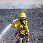 Firefighter/paramedic Margie Brueckner with Clallam County Fire District 2 looks for hot spots at a brush fire near Sherburne Road on Tuesday afternoon. Sequim Gazette photo by Matthew Nash