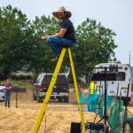 Andy Hilzer of Ellensburg sits atop a yellow ladder as he controls the speed and timing of the white plastic which zips along a line to encourage dogs to run at their fastest speed. He says that he gauges the distance between the plastic and the dog to keep it close enough that they dont loose interest but far enough that they cant catch it during the fast CAT speed challenge. Sequim Gazette photo by Emily Matthiessen