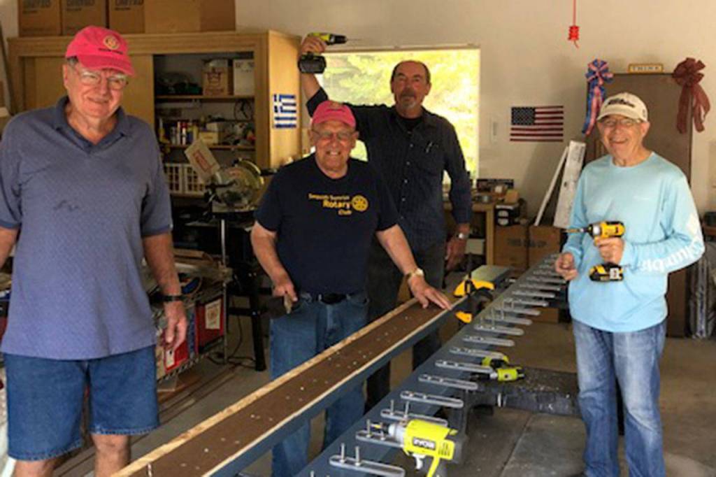 Sequim Sunrise Rotarians, from left, Jack Tatom, Chris Coolures, Ron Long and Rich Benn paint and prep new coat hangers for the Sequim Boys & Girls Club last week. Photo courtesy of Ann Flack