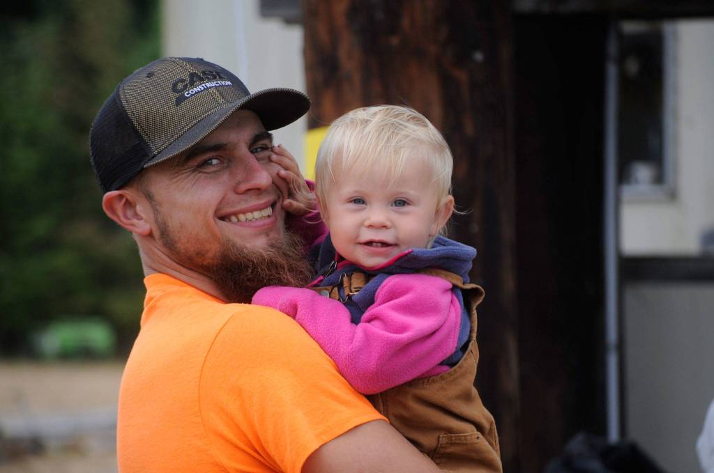 Ben Niclas holds his 11-month-old daughter Lila at the auction on Saturday saying she loved seeing the animals. The dad and daughter were there with wife/mom Kailtin who was helping at the auction. Sequim Gazette photo by Matthew Nash