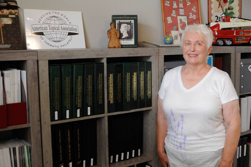 Since she was a girl, Vera Felts, seen standing by her collection of different countrys stamps, said stamps opened up a new world to her. Now shes exhibiting for the first time about lavender stamps at the Strait Stamp Show on Aug. 21 in the Guy Cole Event Center. Sequim Gazette photo by Matthew Nash