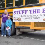 Boys and Girls Club Staff Saul Williams and Camryn Wallen with member volunteer Dallton Wilkinson stand outside the Stuff the Bus bus near Office Depot in Sequim on Aug. 6. Williams says he has been helping at this event for seven years. Sequim Gazette photo by Emily Matthiessen