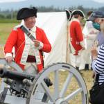 Reenactor Mitch Rice of Milwaukie, Ore., chats with Mimi Starks of Nordlund during the Northwest Colonial Festival over an infantry support cannon in 2020. Sequim Gazette photo by Matthew Nash