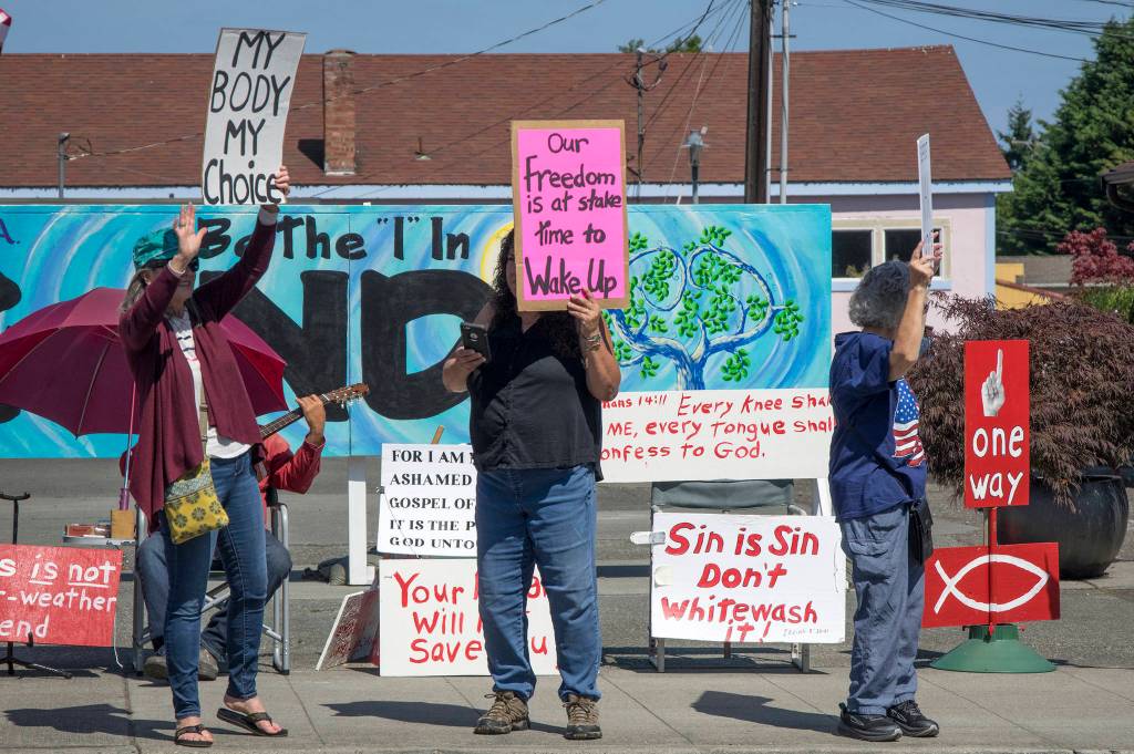Protestors express their opinions with handwritten signs in downtown Sequim on Aug. 18. Sequim Gazette photo by Emily Matthiessen