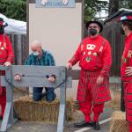 Beefeaters at the service of Queen Elizabeth I lock a man in the pillory after his companion paid a golden coin for the service at Olympia Theatre Arts Renaissance Faire on Aug. 22. Sequim Gazette photo by Emily Matthiessen