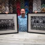 Damon Stamoolis of Sequims Clear Image Custom Framing and Photo holds up two of the historic images he digitally cleaned, printed, and framed for the Port Angeles Police Department. Sequim Gazette photo by Emily Matthiessen