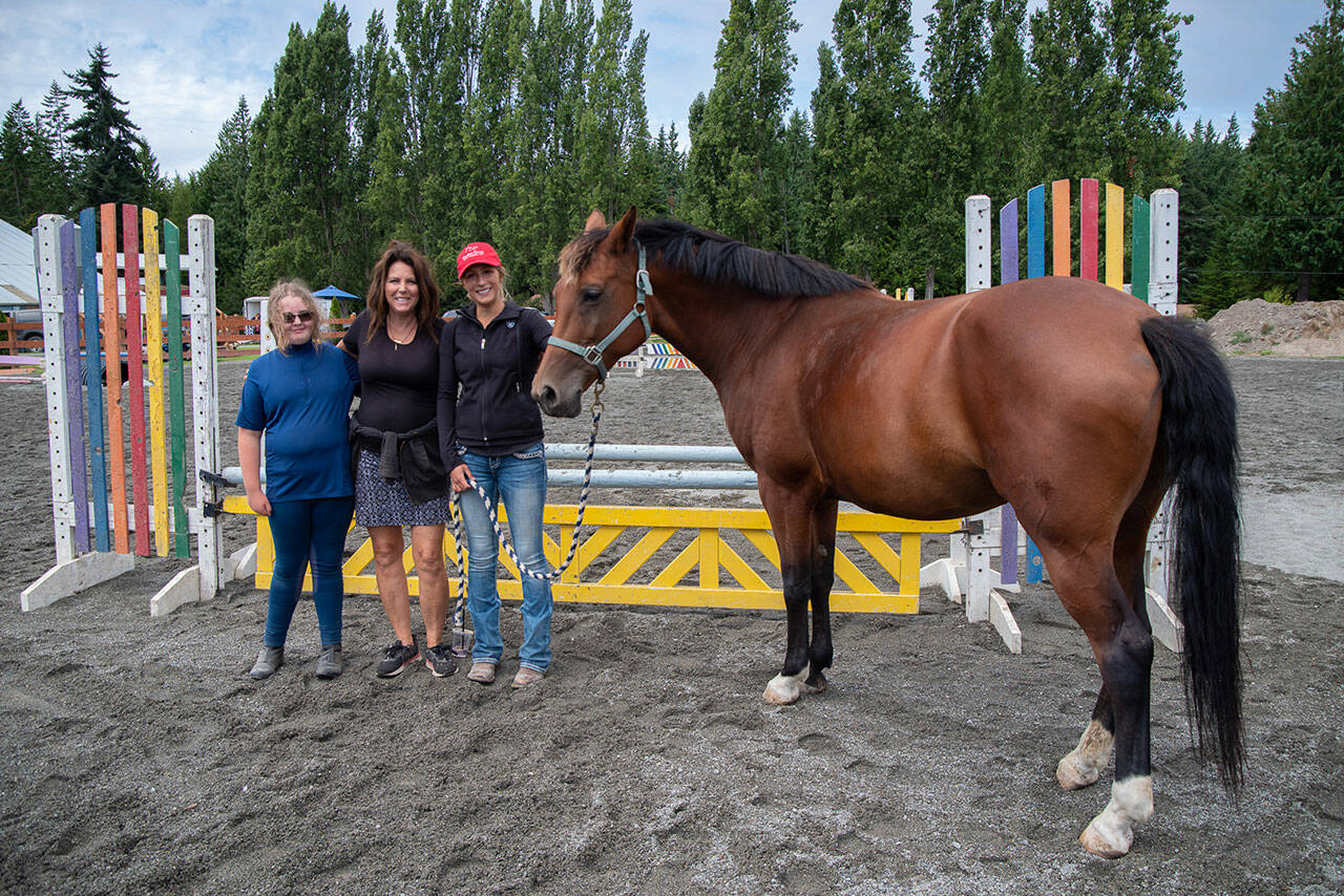 Shay Lucier, Martha Vaughan and Shelby Vaughn stand with Cassie the hourseat Fox-Bell Farms, Port Angeles, during a student show day. Lucier, referred to as Shelbys oldest student by a number of attendees, has been learning conscientious horse care with Shelby since before Shelby bought the farm. Sequim Gazette photo by Emily Matthiessen
