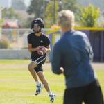 Sequim receiver Isaiah Moore, left, catches a pass from assistant coach Frank Catelli at a preseason practice last week. Moore was a second team all-Olympic League receiver in the 2020/21 season. Sequim Gazette photo by Michael Dashiell
