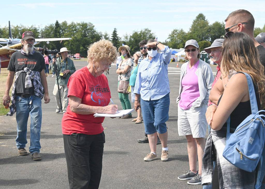 Emily Westcott, Olympic Peninsula Air Affaire and Fly-In organizer (center), helps event attendees check in for plane rides Saturday afternoon. Sequim Gazette photo by Michael Dashiell