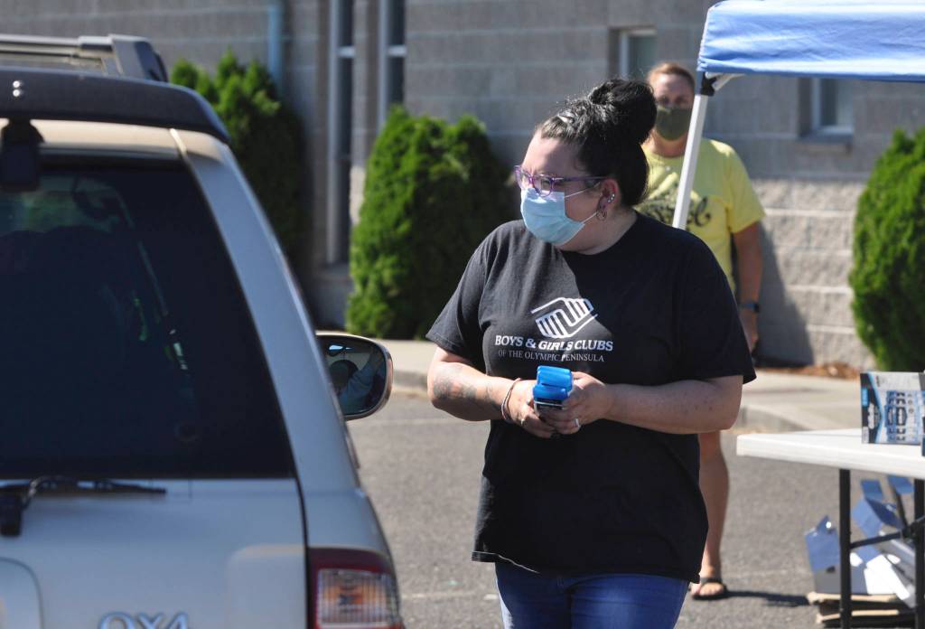 Heather Baker, art room director at the Sequim Boys & Girls Club, greets attendees and hands out supplies at the 2021 Back to School Fair on Aug. 28. Sequim Gazette photo by Michael Dashiell