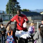 Joclin Julmist, physical education teacher at Helen Haller Elementary, hands out breakfasts to students on the first day of school, Sept. 1, as they get off and on buses for both Haller and Greywolf Elementary schools. Sequim Gazette photo by Matthew Nash