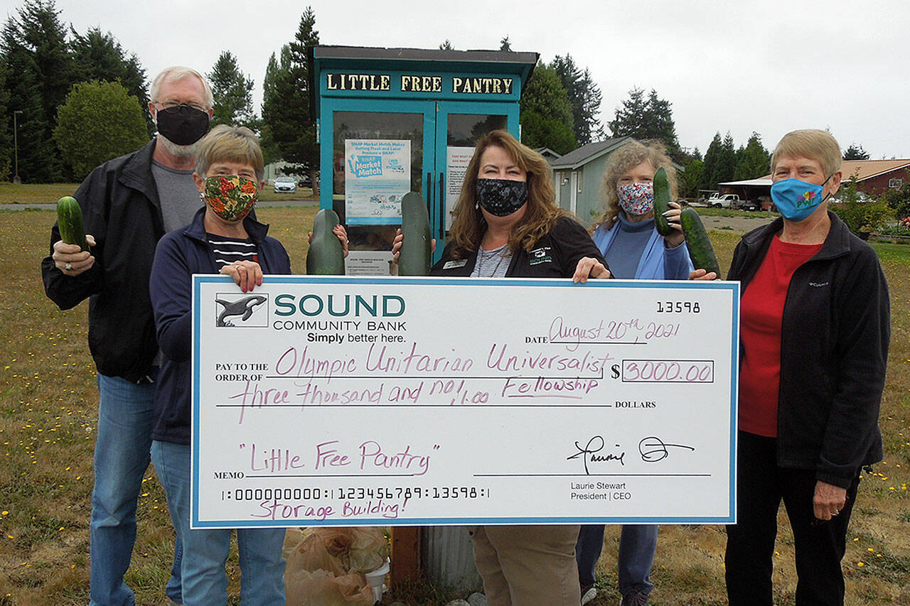 Shelli Robb-Kahler, Sound Community Bank vice-president and Sequim branches manager, third from left, presents $3,000 to attendees of Olympic Unitarian Fellowship, from left, Greg and Vicki Sensiba, Dianne Whitaker and Florence Bucierka on Aug. 20 to help pay for the Little Free Pantry in Agnews new storage facility. Photo courtesy of Sound Community Bank