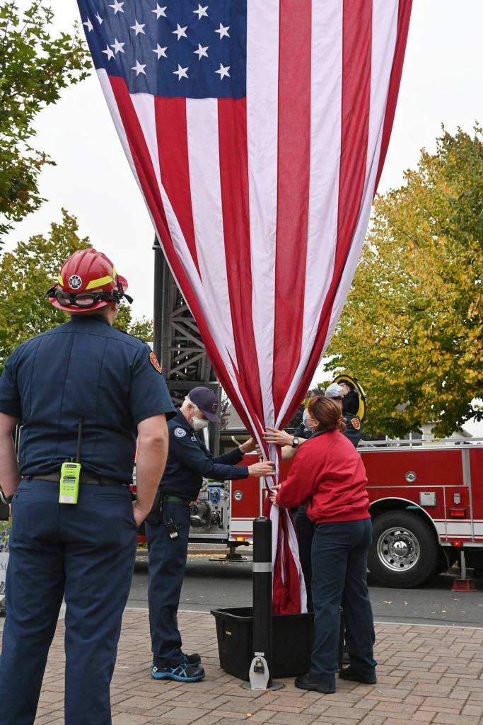 Clallam County Fire District 3 staff carefully place a massive American flag away for storage following a 9/11 remembrance ceremony. Sequim Gazette photo by Michael Dashiell