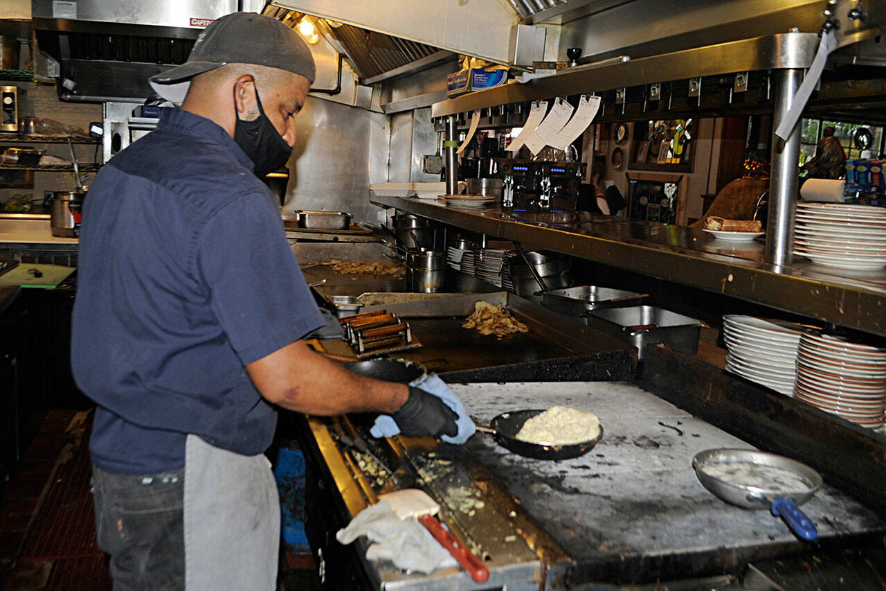 Cook Roberto Lara prepares an omelette on Monday at the Oak Table Café. Managers hope to have enough staff in the coming weeks to reopen seven days a week and reoffer a lunch menu after staffing shortages led them to close for two days at first, and then one day a week. Sequim Gazette photo by Matthew Nash