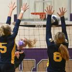 Sequims Kendall Hastings, center, looks to hit past the block of Bainbridges Izzy Prentice (5) and Scarlett Bos (8) in the Wolves 
Sept. 21 home match against Bainbridge.