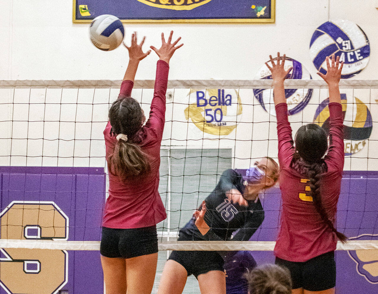 Sequims Kendall Hastings, center, hits past a couple of Kingston would-be blockers in a Sept. 28 Olympic League match. Hastings Wolves won, 3-1, to improve to 4-2 in league play. Sequim Gazette photo by Emily Matthiessen