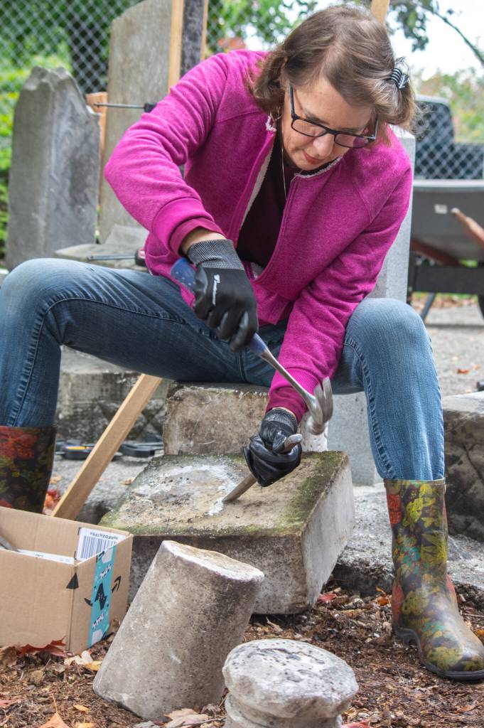 Suzan Mannisto chips away at old mortar during a restoration effort at Sequims Pioneer Memorial Park. Mannisto and her husband, Daniel Mannisto, took before and after pictures of the changes made by an all-volunteer crew in a fenced corner of the park.