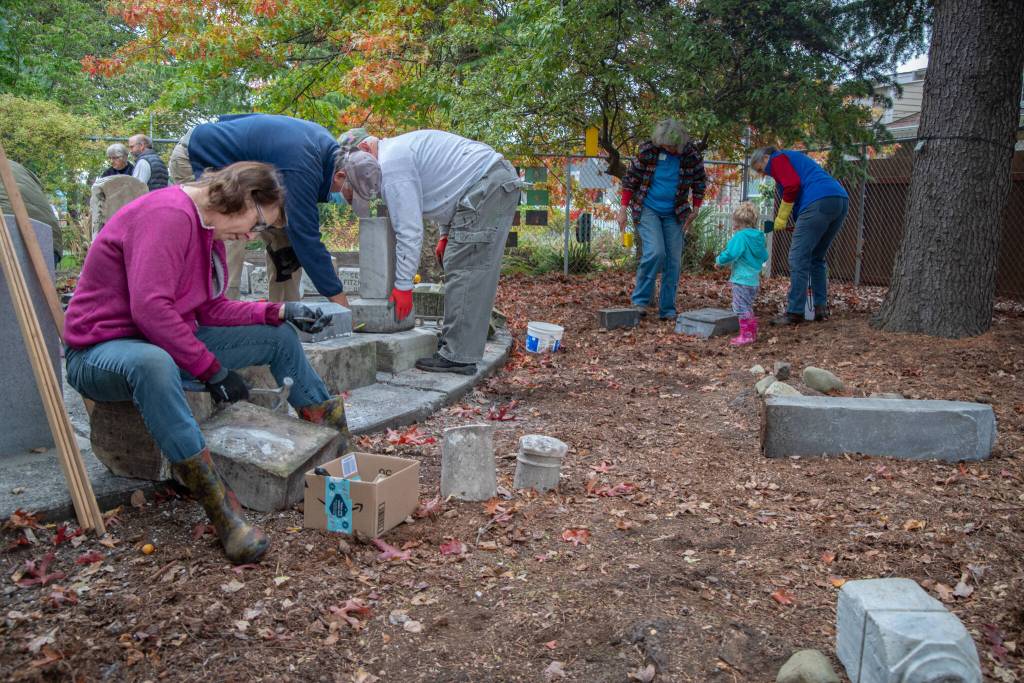 Volunteers work to improve the memorial corner created by Sequim Prairie Garden Club members in the 1960s at Pioneer Memorial Park. The history of the club and the park are intertwined, and from the beginning the club has cared for this 4 acre former cemetery with the aid of community members, turning it into the lush park off Washington Street that all residents and visitors can enjoy. The headstones in the memorial corner were fenced in the early 1980s due to vandalism that occurred through the years. Current members of the club requested that anyone in the community who may have a piece of one of the stones to please return it. Sequim Gazette photo by Emily Matthiessen