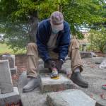 In general, power tools arent used during cemetery restorations, according to Marion Mick Hersey, National Historical Preservationist. In this case, Roy Harlson is using (?) to grind away old mortar from a base stone which had been combined with an unmatching headstone. This mistake was made in the 1960s when a memorial corner was created in the corner of Sequim Pioneer Memorial Park. Members of the Sequim Prairie Garden Club and Michael Trebert Chapter of the DAR, as well as other volunteers, worked to fix past mistakes and vandalism under the tutelage of Hersey this autumn and will finish their work in the spring. Sequim Gazette photo by Emily Matthiessen